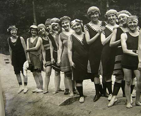 Camp Highland girls standing in line, wearing old-fashioned swimsuits and caps. Elsie third from right.